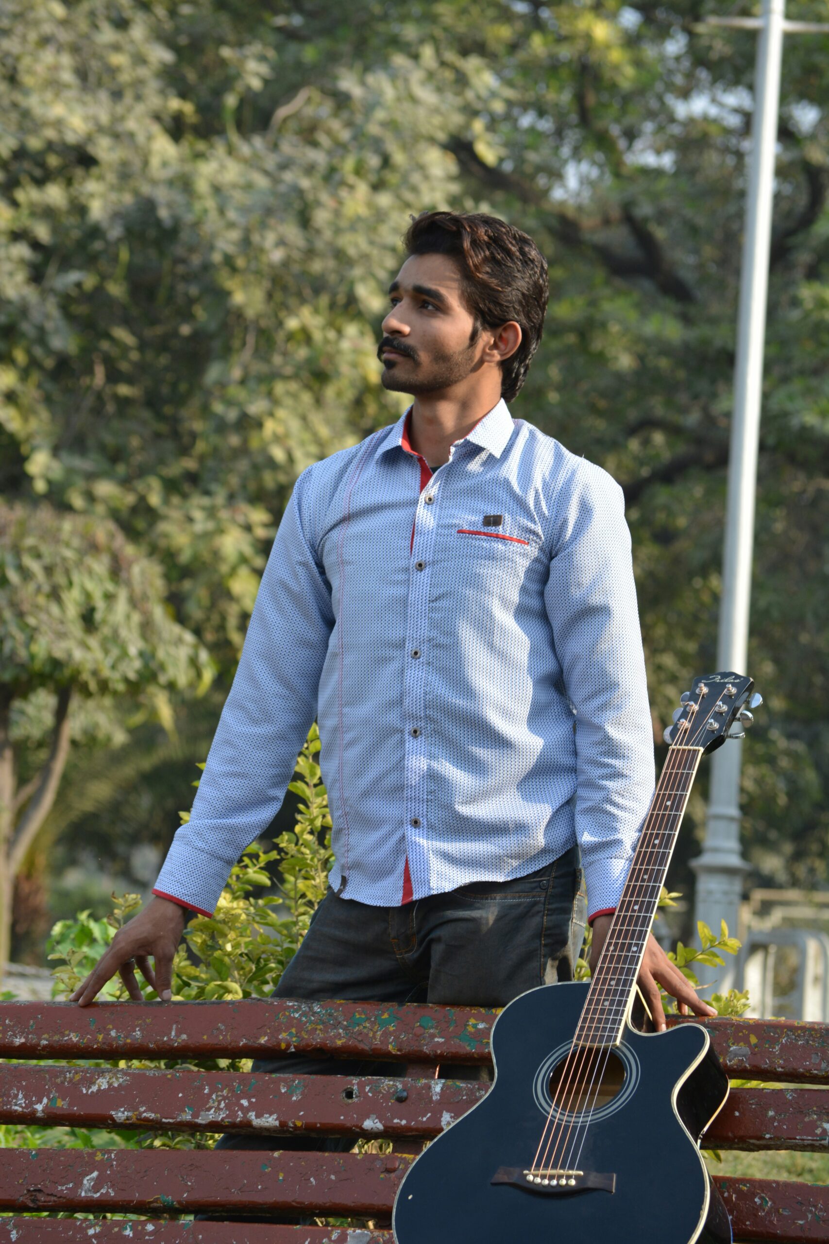 man in blue dress shirt playing guitar