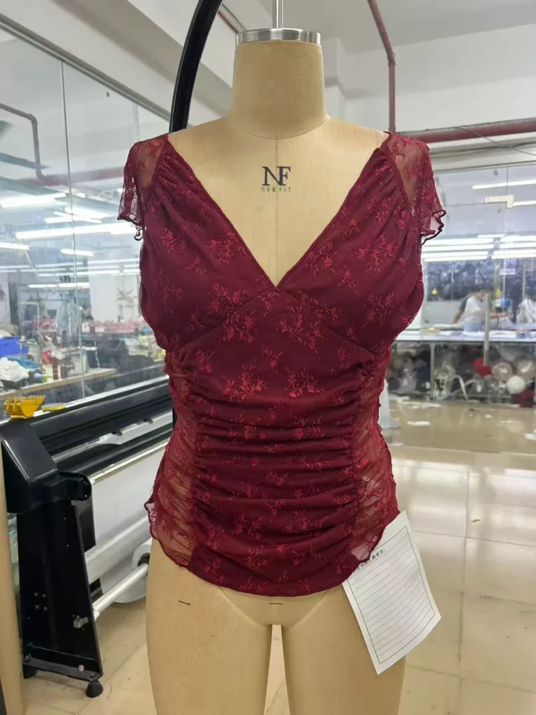 Burgundy sleeveless V-neck top with a ruched front on a mannequin.