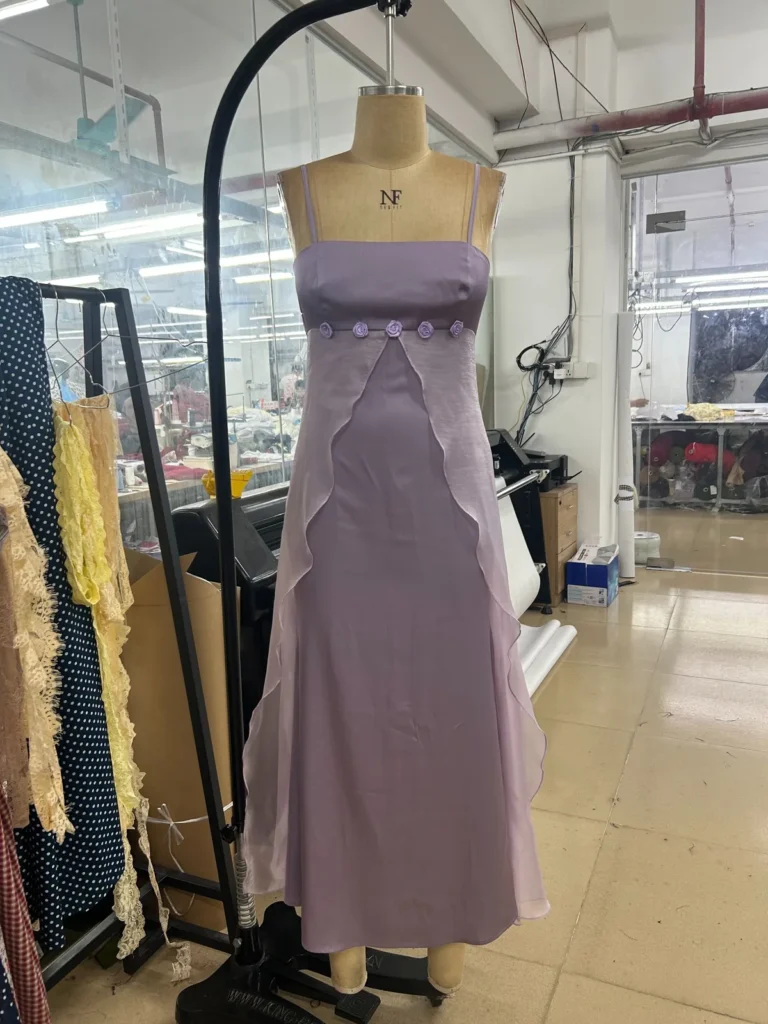 Lavender midi dress with thin shoulder straps and decorative bodice panels on a mannequin.