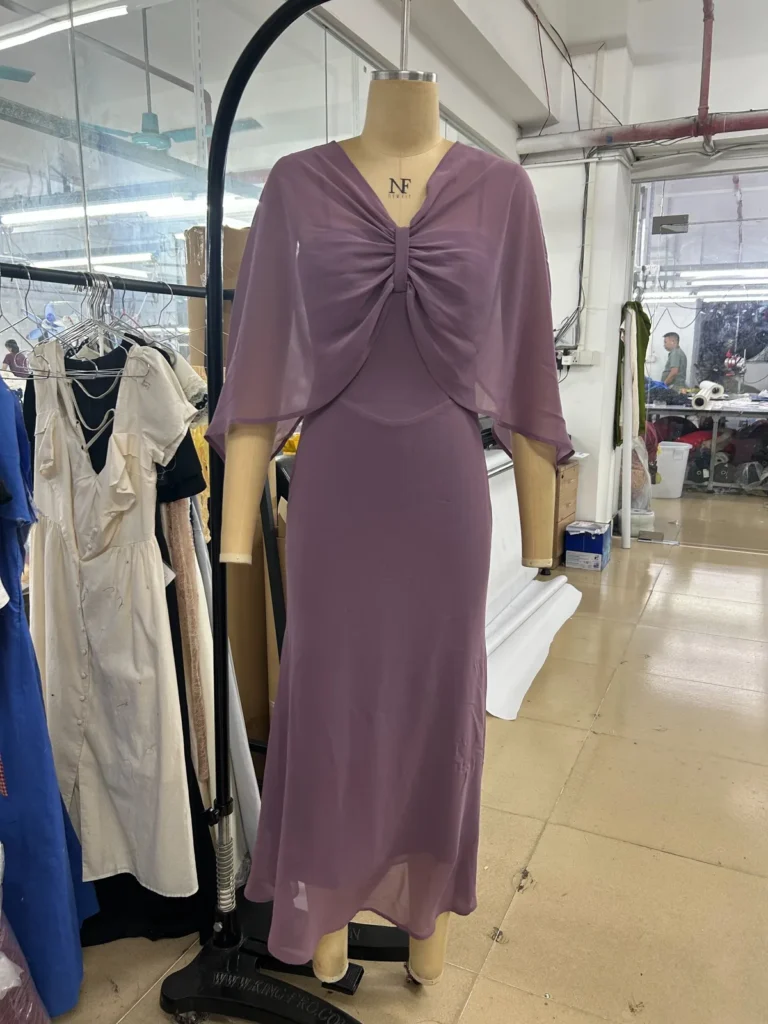 Mauve midi dress with a ruched bodice and elbow-length sleeves on a mannequin.