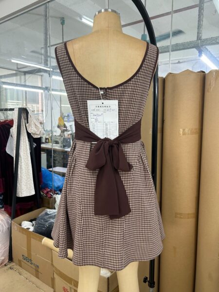 Brown check woven dress sample with a bow-back detail