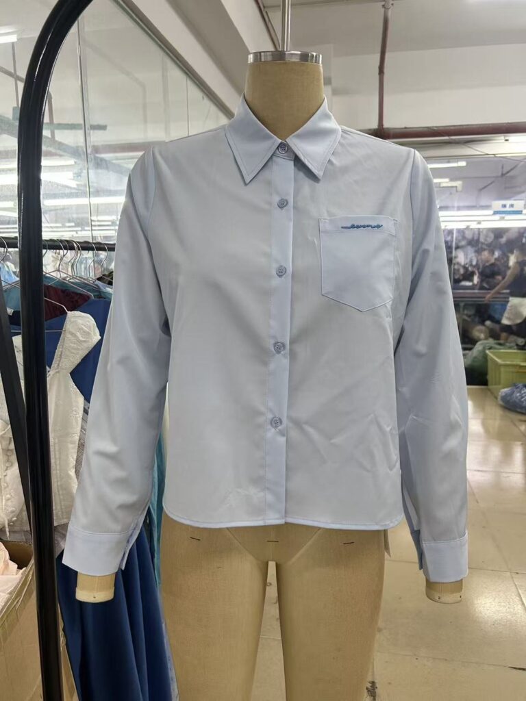 Light blue button-front shirt displayed on a mannequin