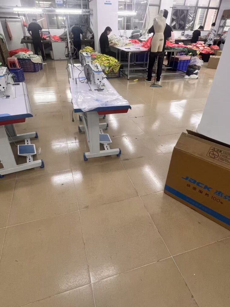 Garment pressing tables and a dress form in a clothing sample workspace