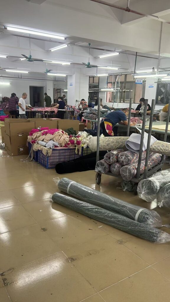 Fabric rolls and garment baskets beside occupied workshop tables