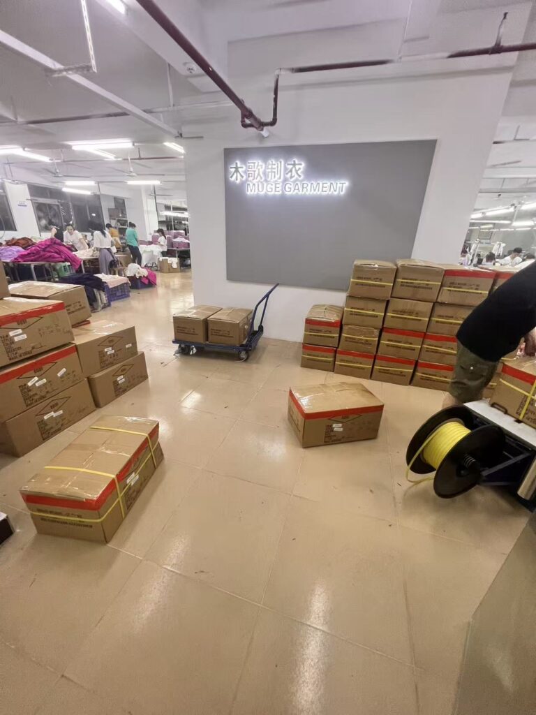 Sealed cartons arranged around the reception wall beside the garment production floor