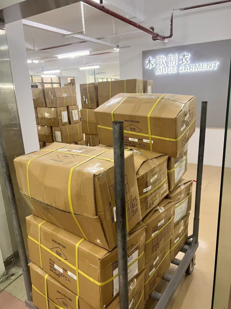 Sealed cartons secured with yellow straps on a metal transport trolley