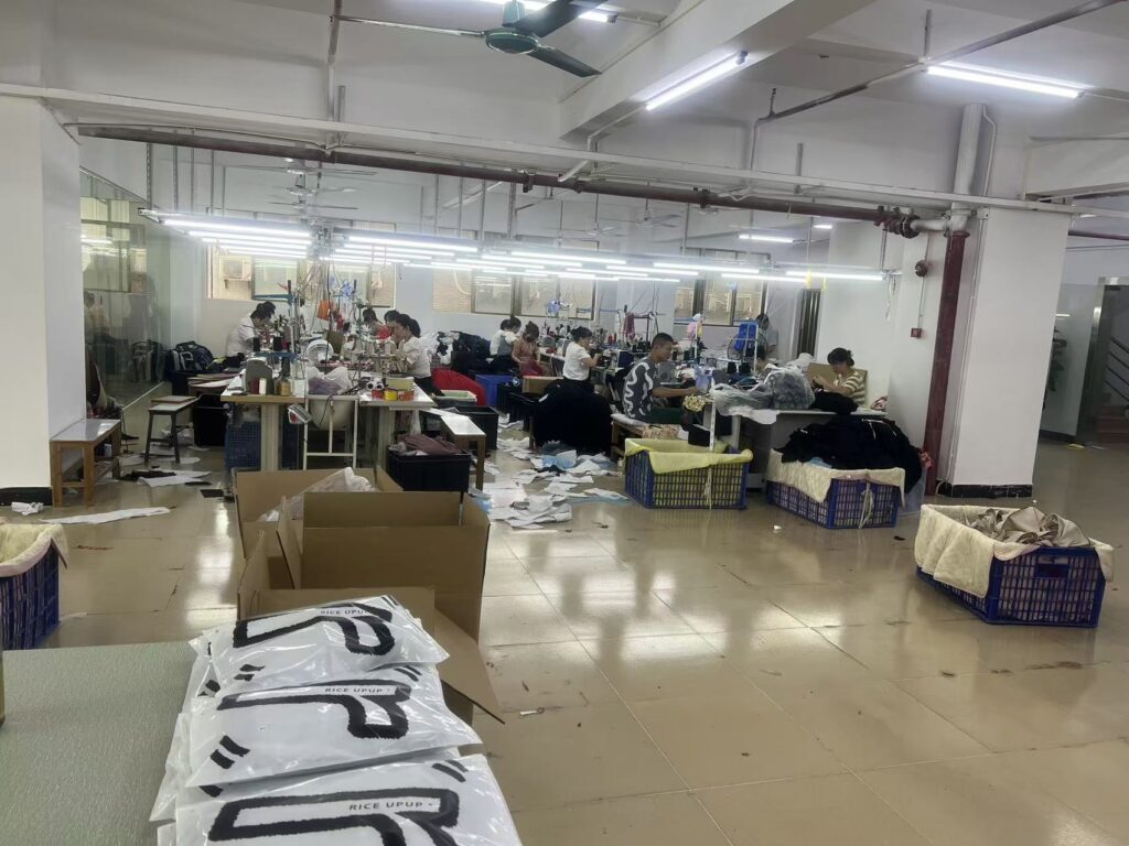 Paper garment patterns in the foreground with sewing workers across the workshop