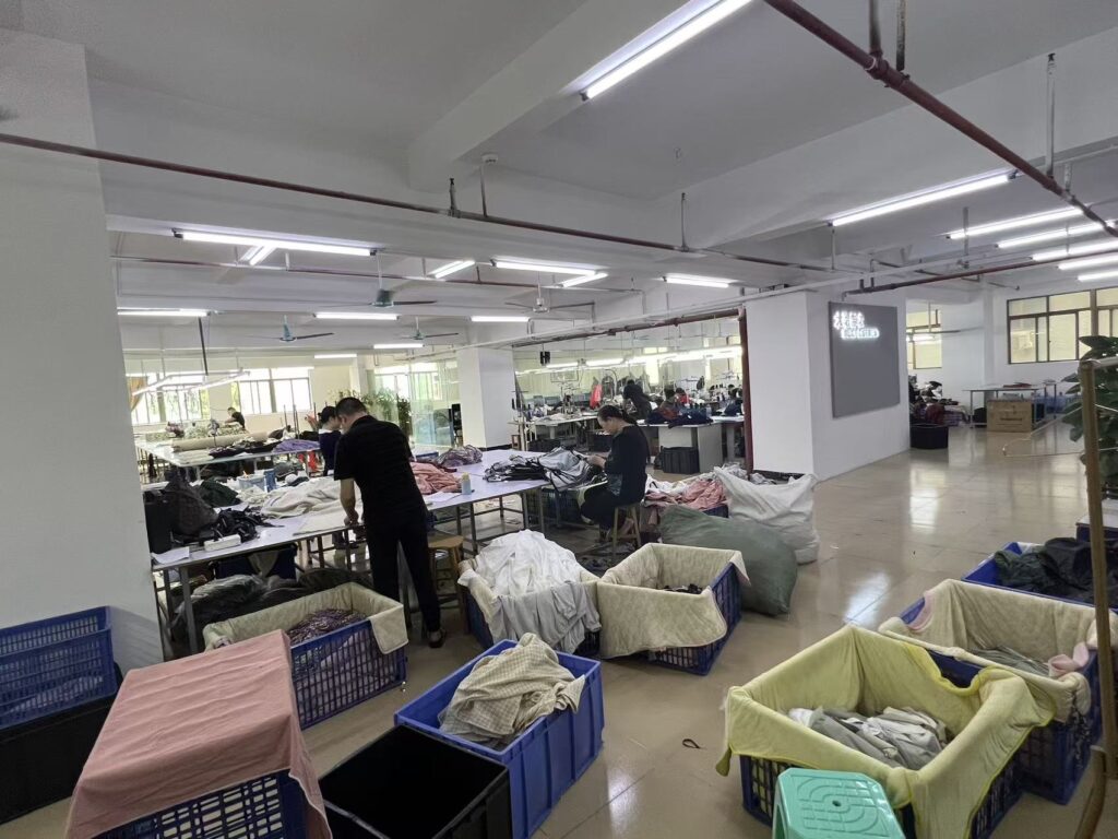 Workers and garment bins arranged around tables in a clothing production area