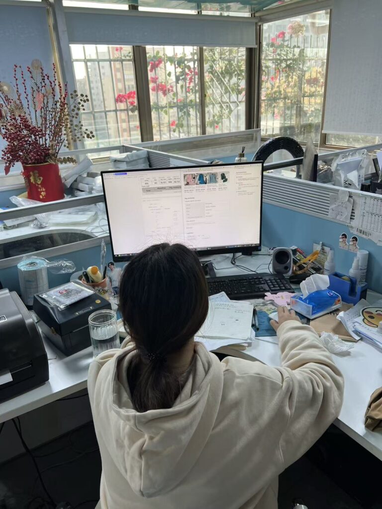 Staff member working at a computer beside a workshop window