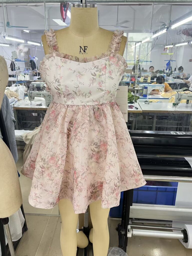 Pink floral sleeveless dress with a square neckline and gathered skirt on a dress form