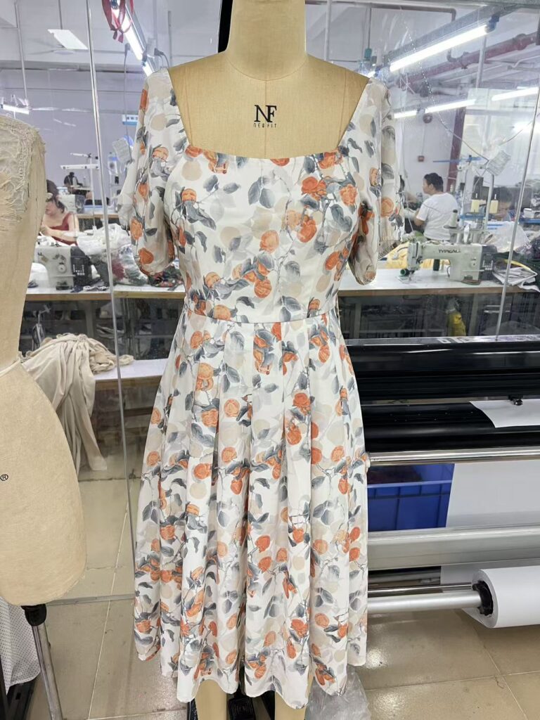 Cream floral print dress with a square neckline and short sleeves on a dress form