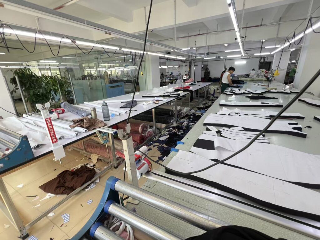 Large paper garment patterns on a wide format plotter beside workshop tables