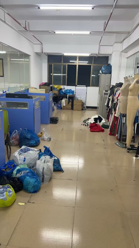 Aisle between office desks, garment samples and dress forms