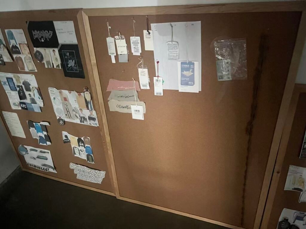 Garment sketches, reference photos and fabric swatches pinned to a development board