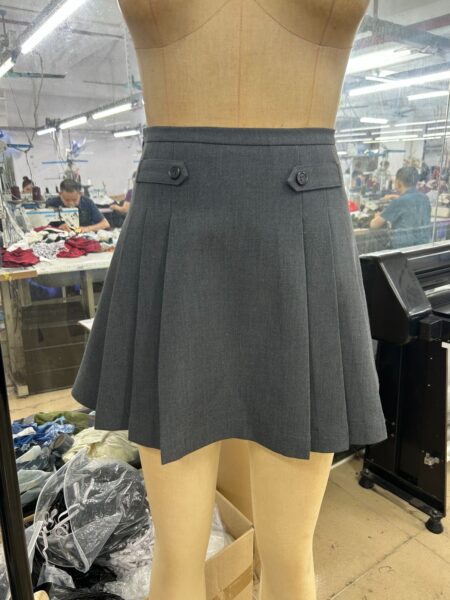 Grey pleated mini skirt with a waistband displayed on a mannequin