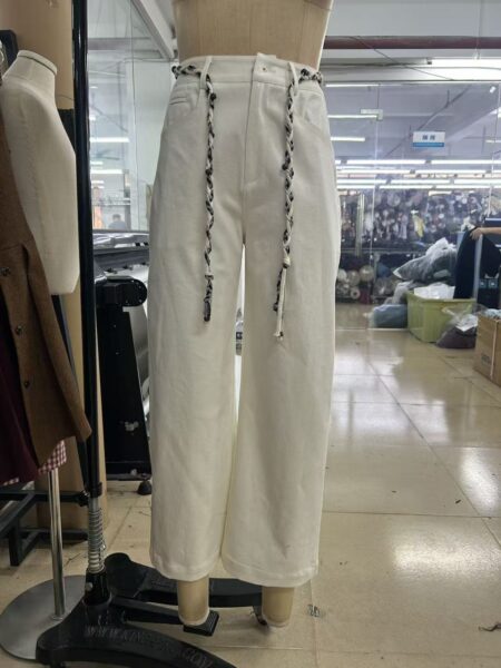 White wide-leg trousers with braided waist ties displayed on a mannequin