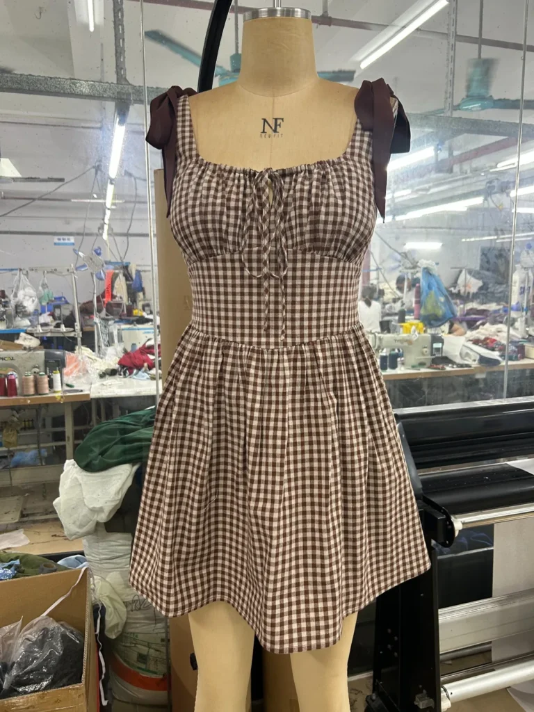 Brown gingham sleeveless mini dress with a fitted bodice and flared skirt