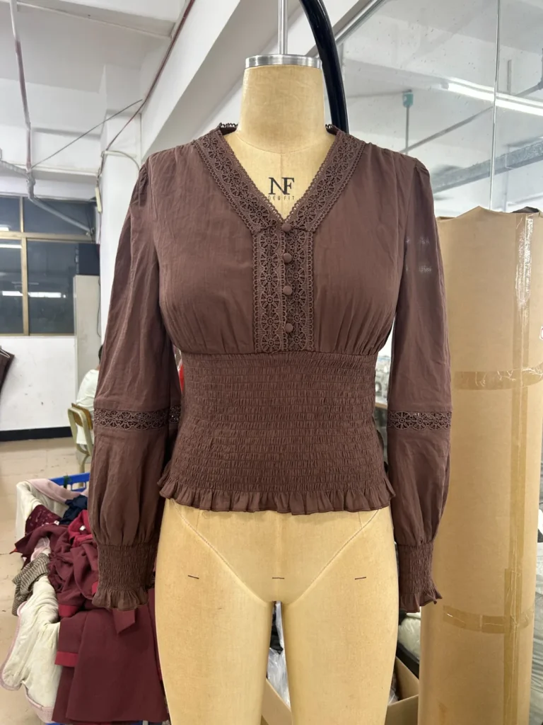 Brown long-sleeve V-neck blouse with a fitted waist on a mannequin
