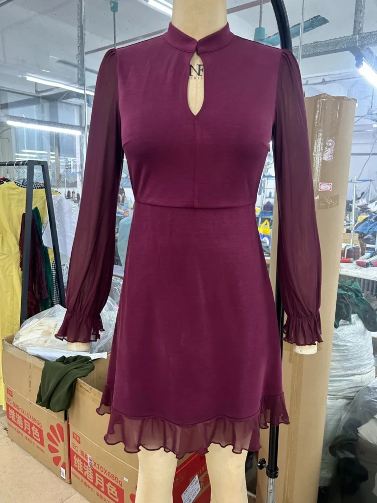 Burgundy long-sleeve mini dress with a keyhole neckline and sheer hem trim
